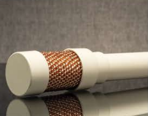 White cylindrical object with a copper mesh band on a reflective surface