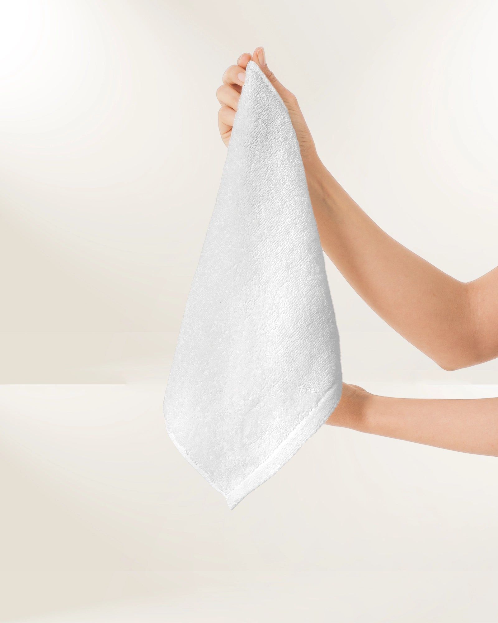 Hands holding a white towel against a light background