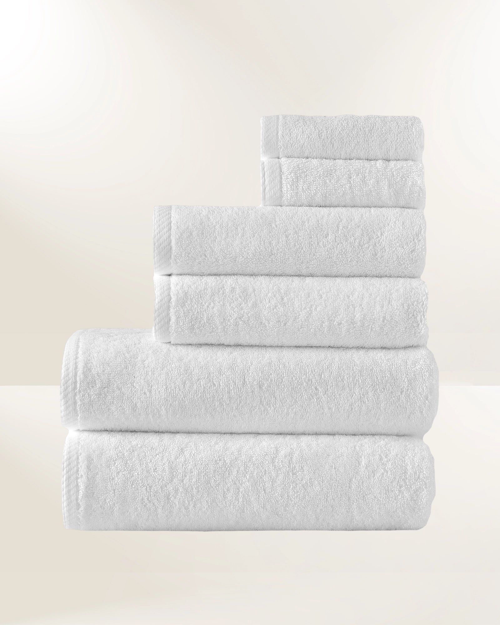 Stack of neatly folded white towels on a light background