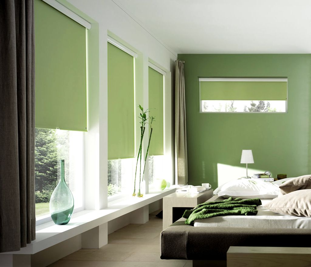 Modern bedroom with green walls, large windows, and a bed with green bedding