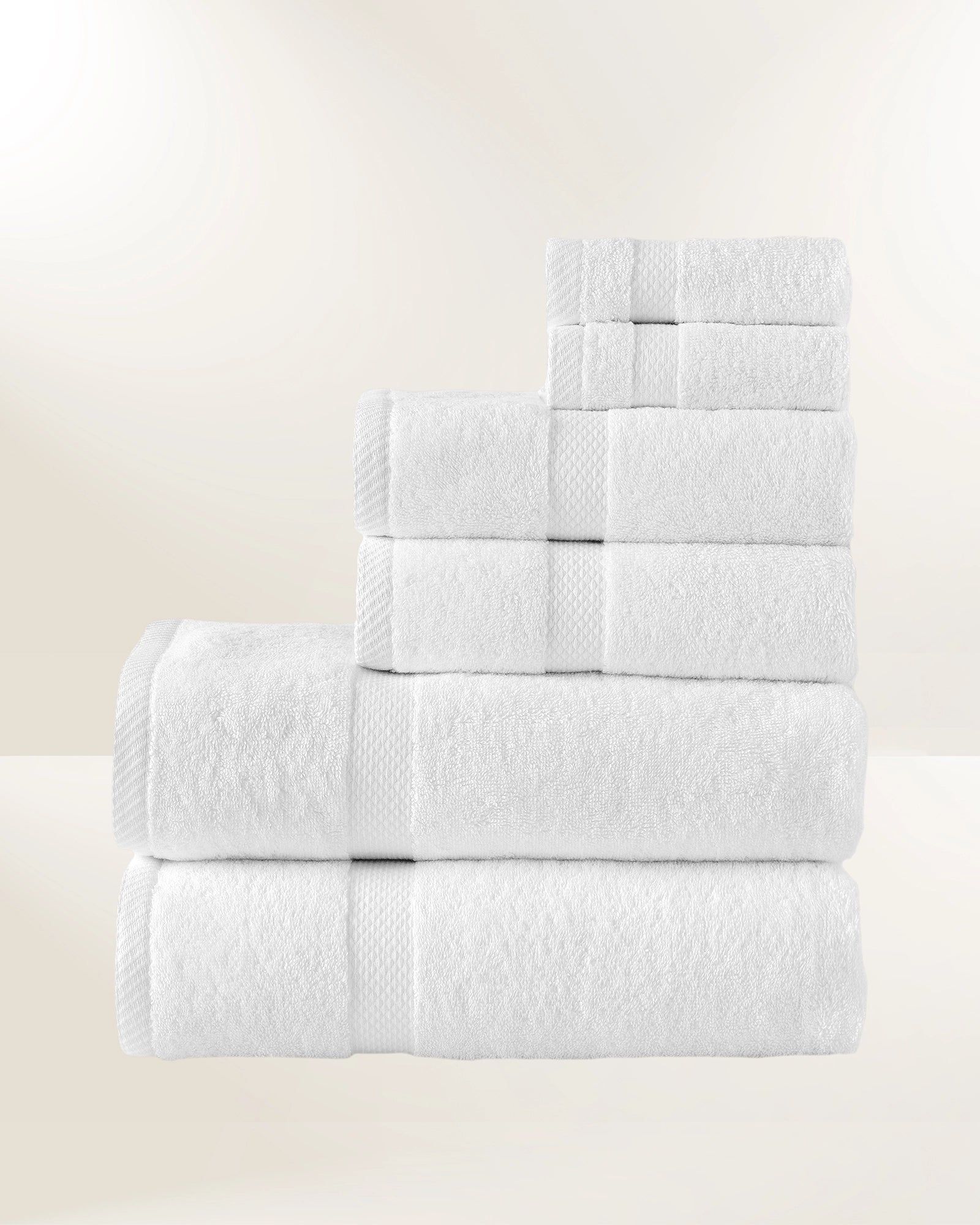 Stacked white towels on a light background, arranged in a stepped display.