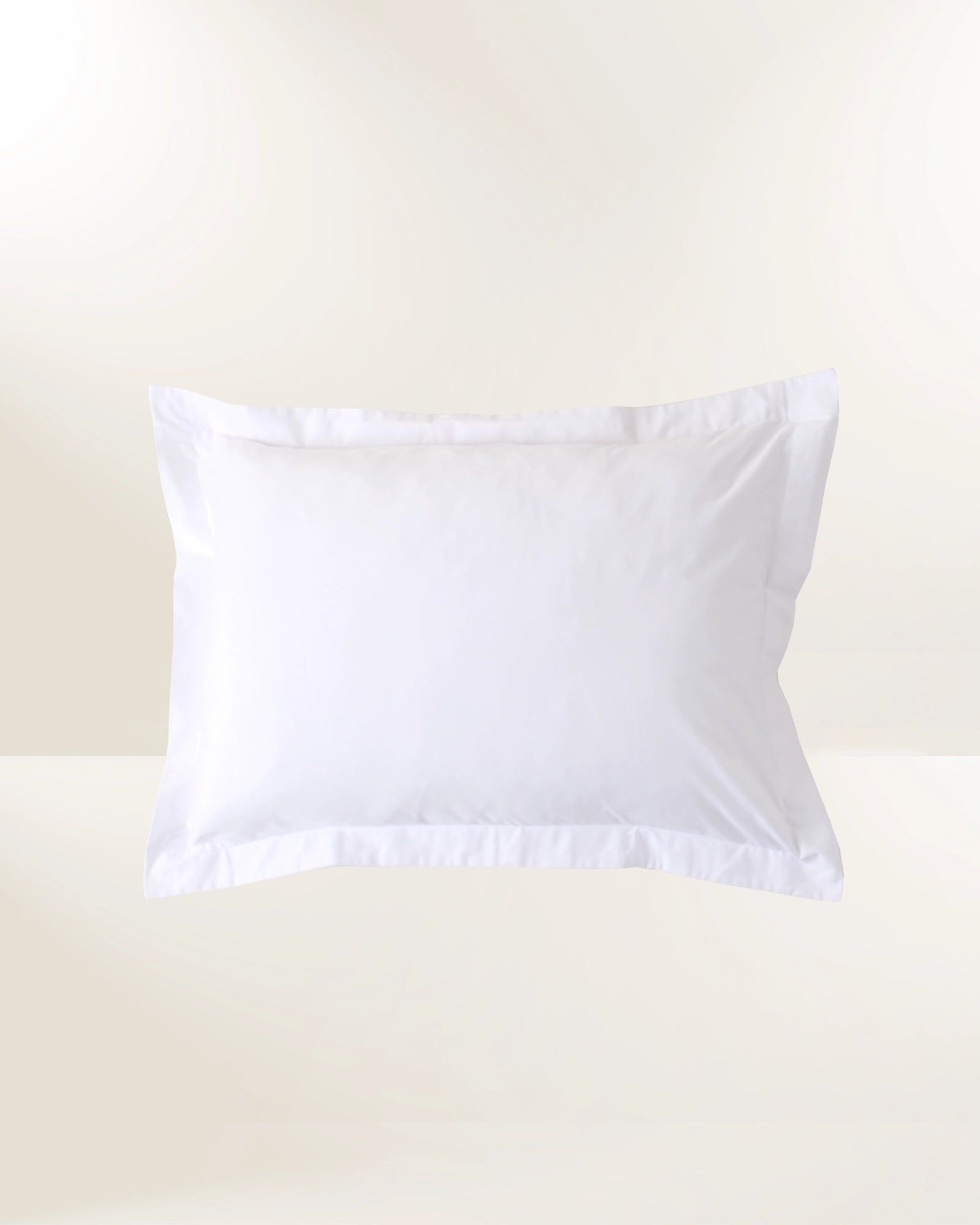 White pillow with ruffled edges on a light beige background