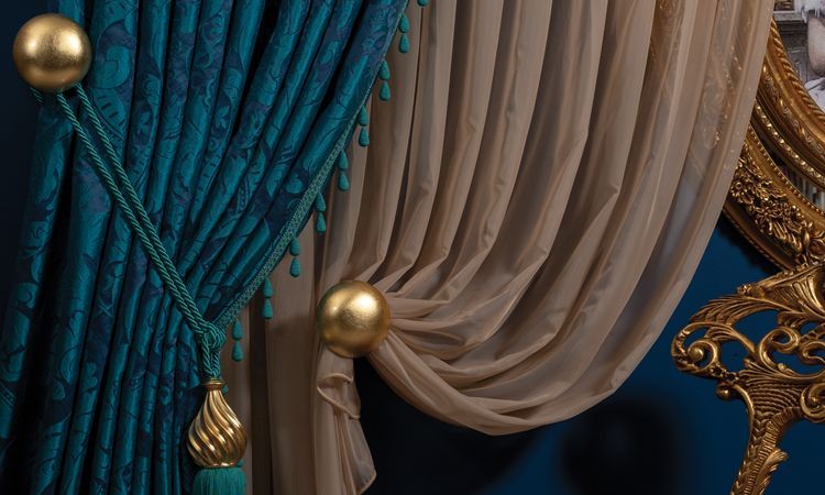 Teal and beige draped curtains with gold tassels and ornate trim on a decorative backdrop