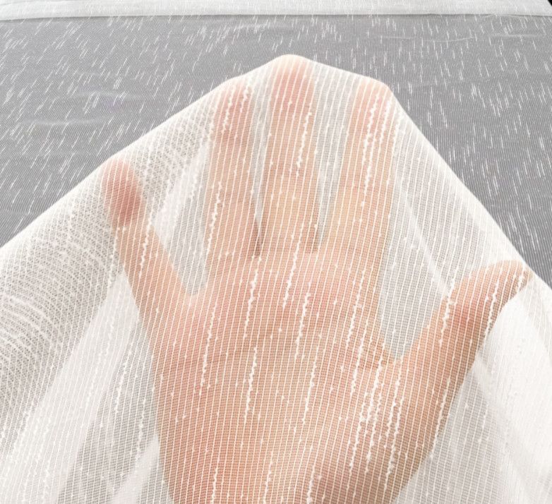 A hand covered by a white mesh cloth, palm facing up, over a gray background