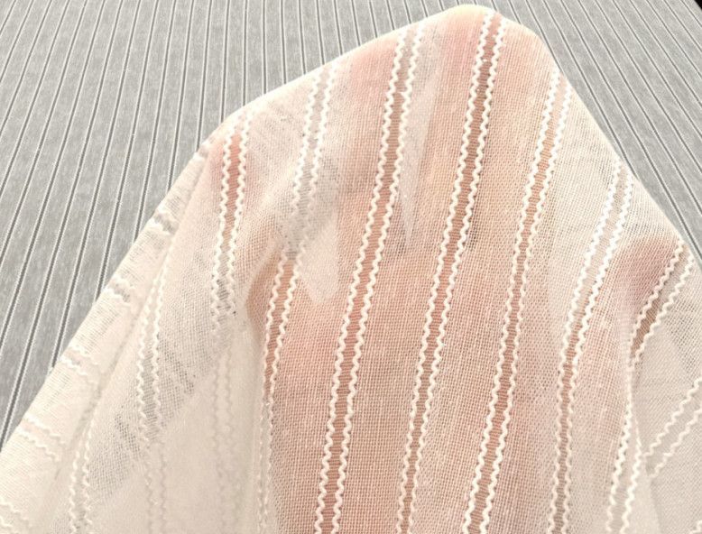 Sheer blush-pink fabric with vertical white stripes draped over a person’s lap