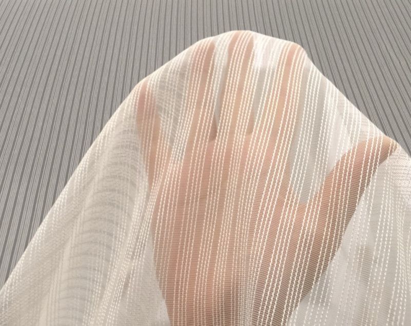 White and peach striped fabric draped in a rounded shape on a gray textured surface.