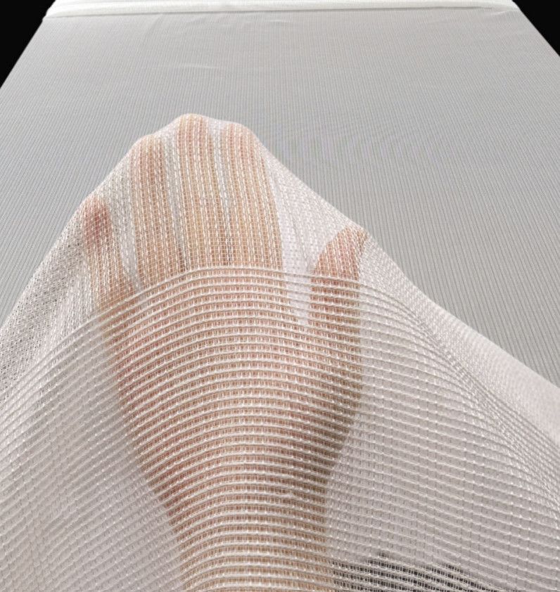 Hand reaching up behind a sheer white curtain with a soft striped pattern