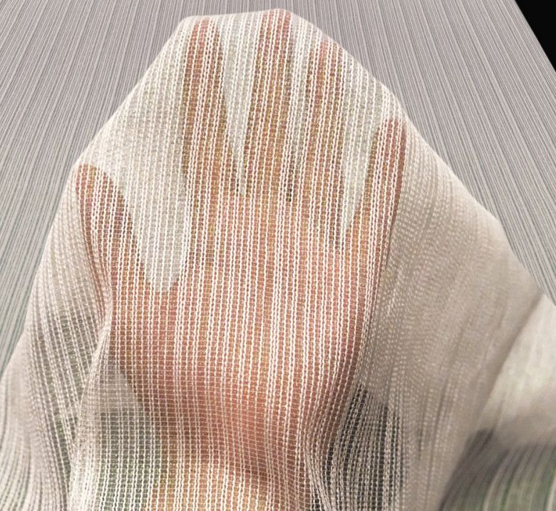 A hand pressing against a sheer white curtain, with a gray textured background