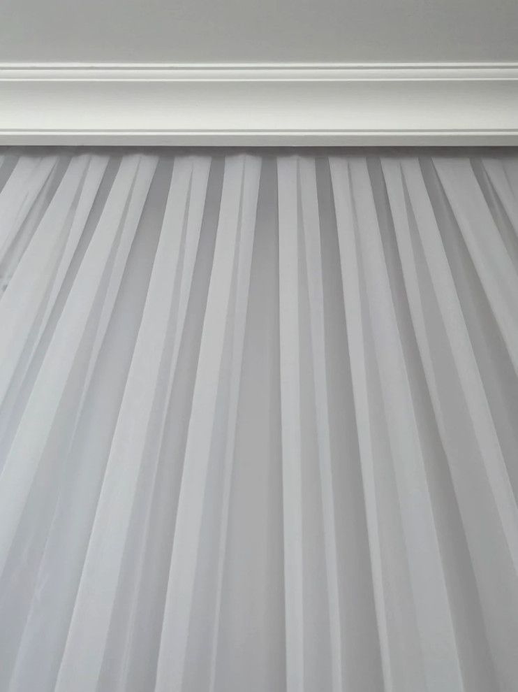 Gray pleated curtain with a white valance at the top