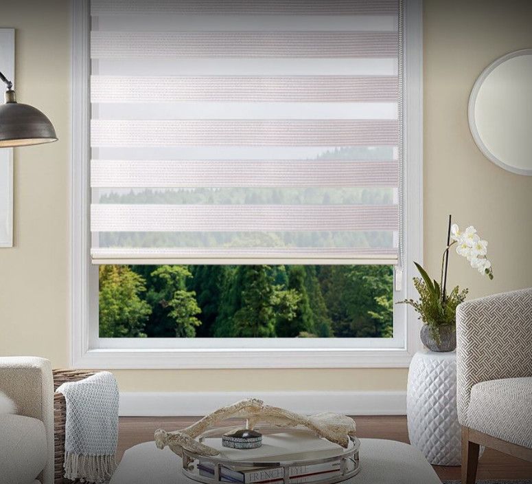 Living room window with white blinds, green garden view, and modern chairs with a side table