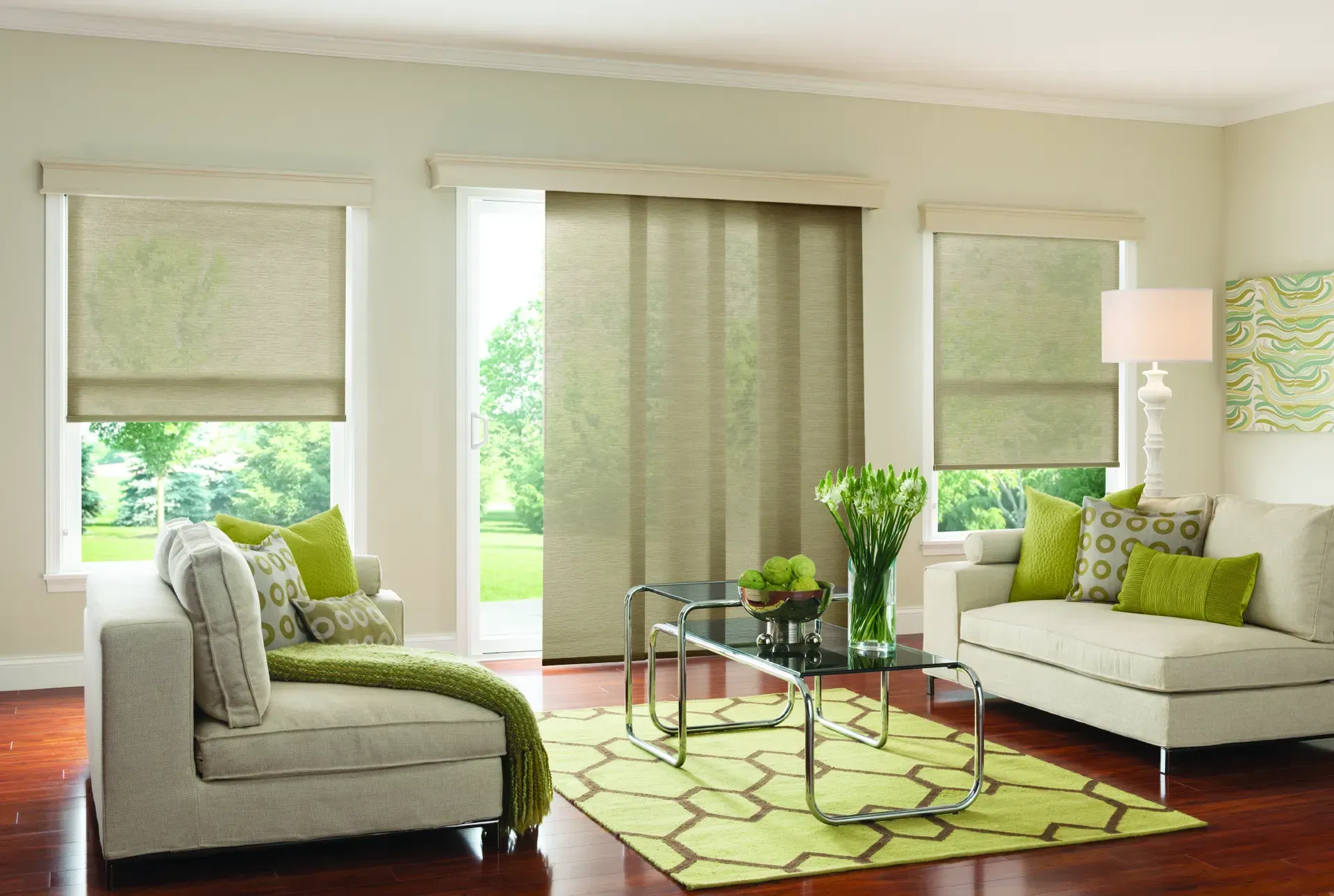 Bright living room with white sofas, green accents, large windows, and hardwood floors