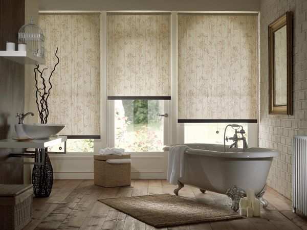 Elegant bathroom with freestanding tub, lace blinds, wicker basket, and neutral decor