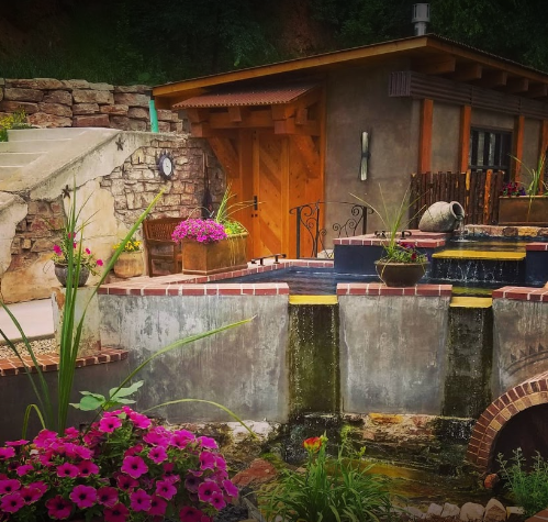 Spa with a pond and flowers in front of it