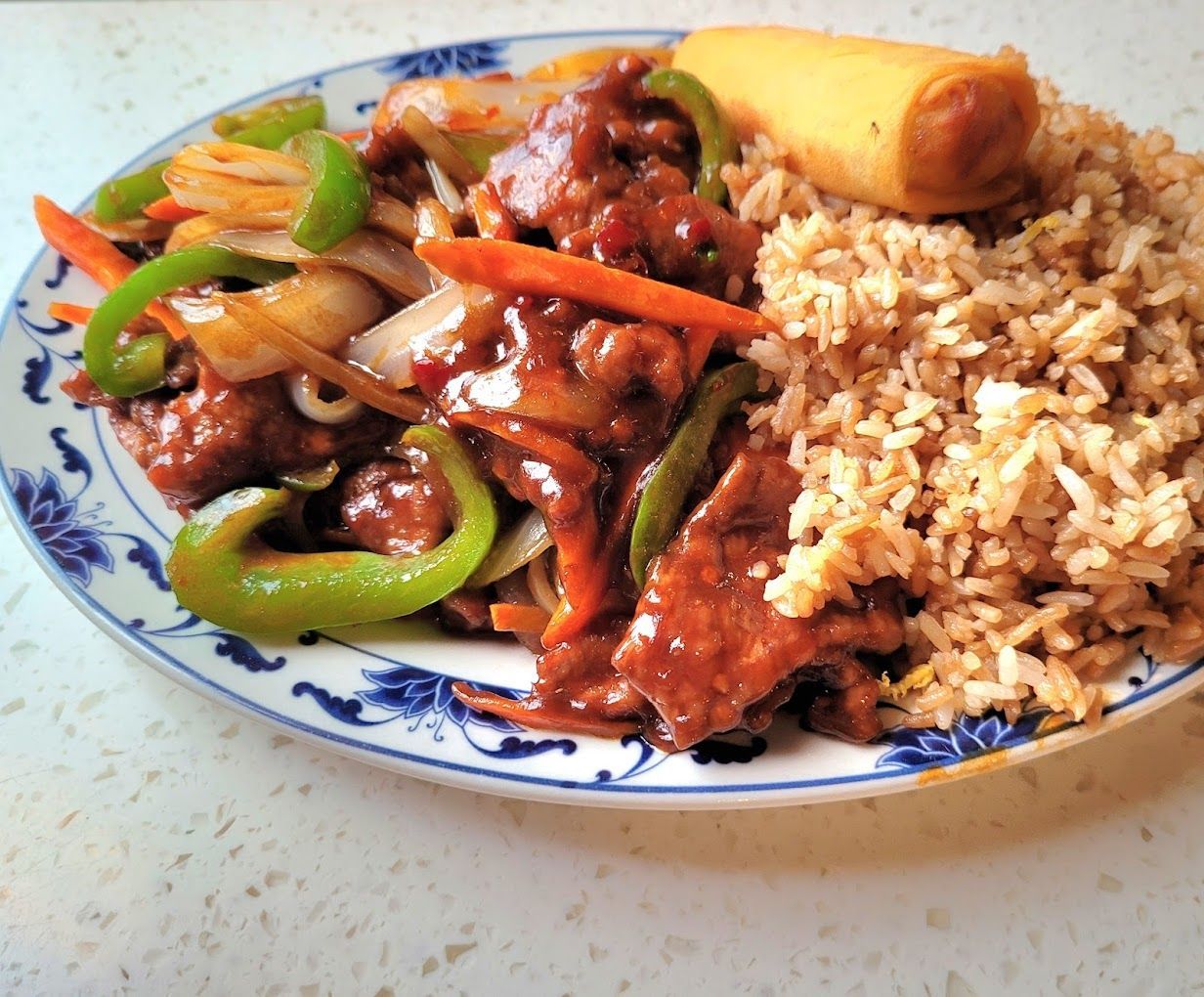 A plate of food with rice and vegetables on a table