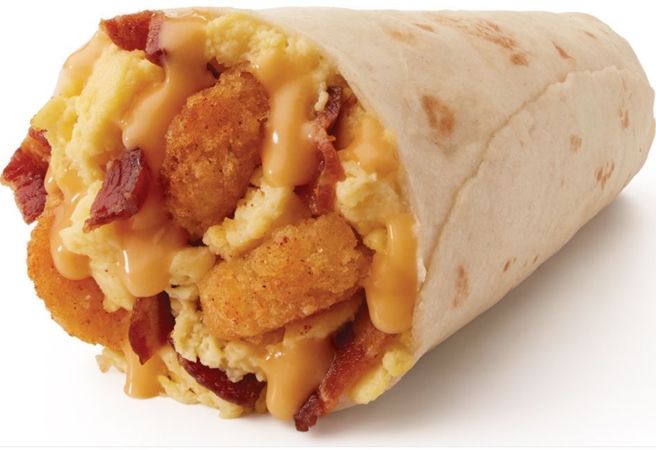 A burrito with eggs , bacon and cheese on a white background