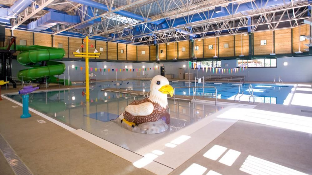 A large indoor swimming pool with a statue of an eagle in the middle.