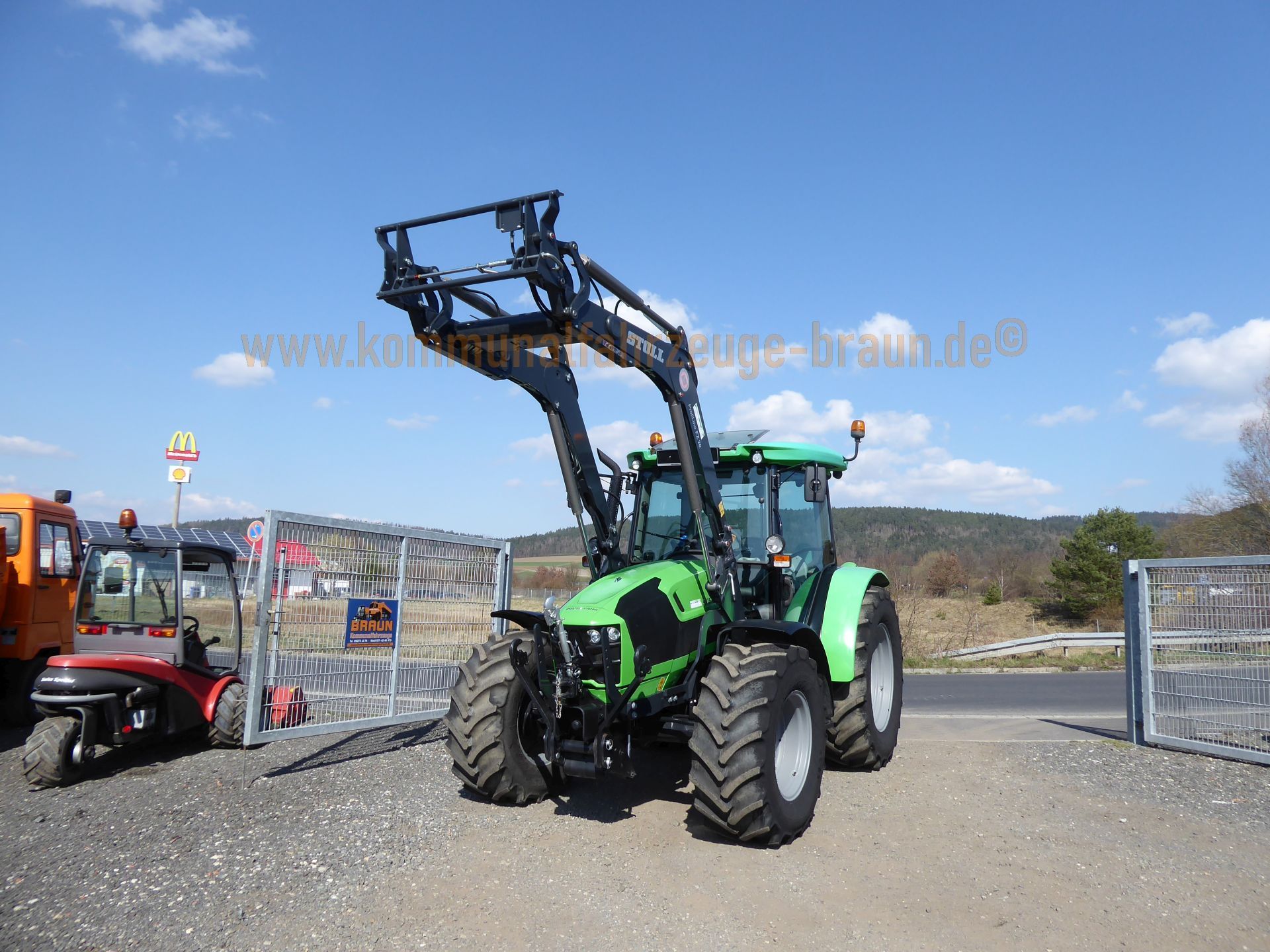 A green tractor is parked on the side of the road