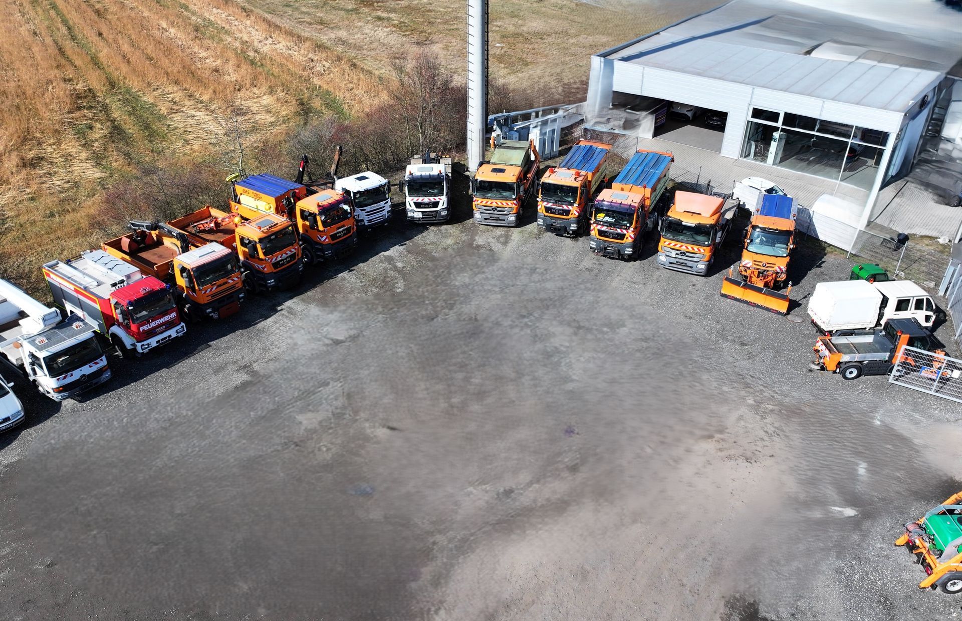 An aerial view of a row of trucks parked in front of a building.