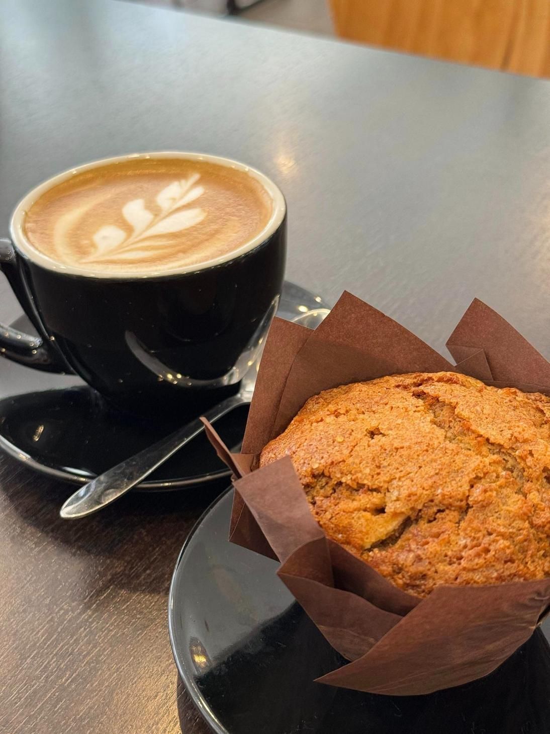 A Cup Of Coffee And A Muffin Are On A Table — Top Point Café In East Gosford, NSW