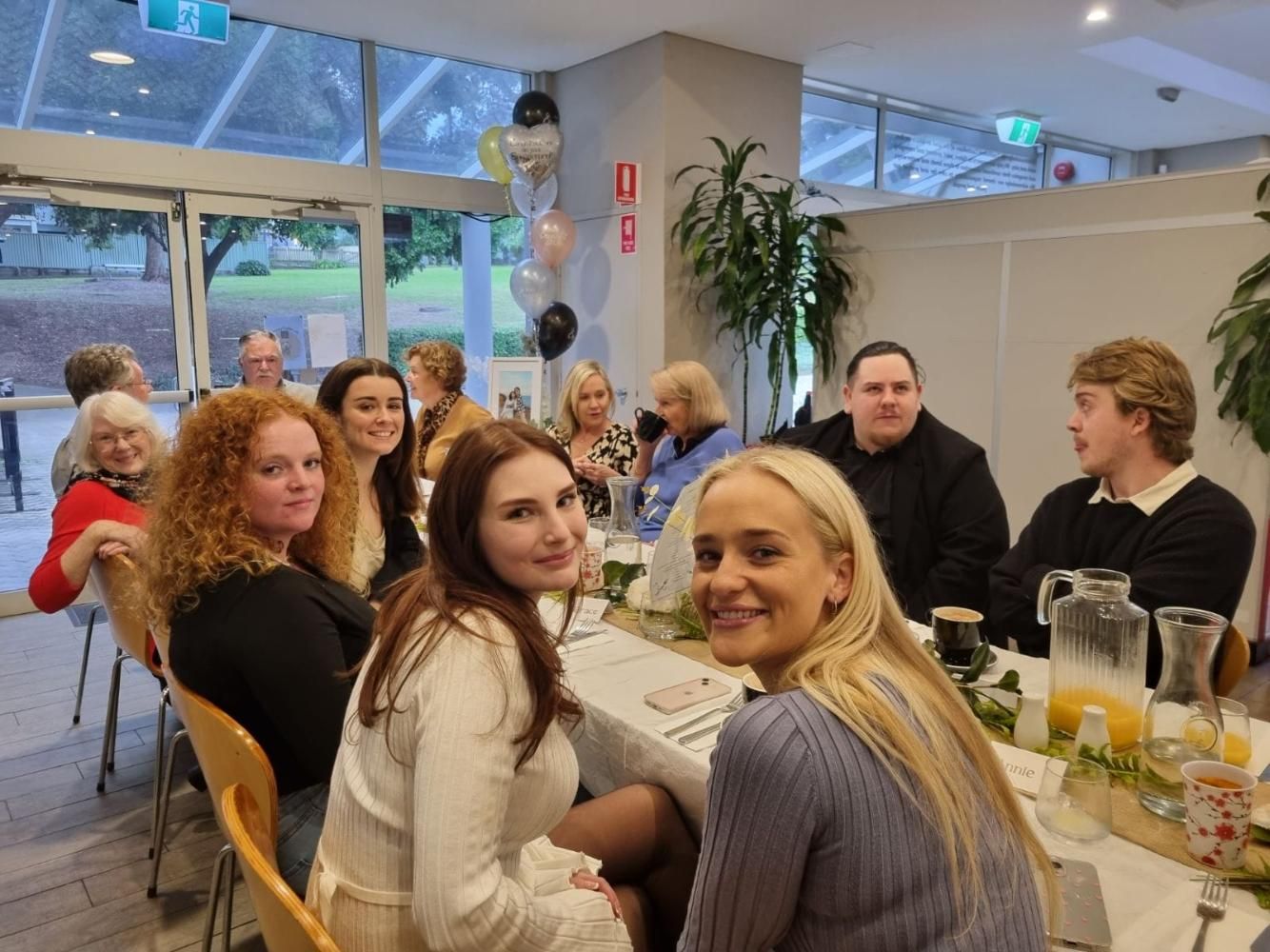 A Group Of People Are Sitting At A Table In A Room — Top Point Café In East Gosford, NSW