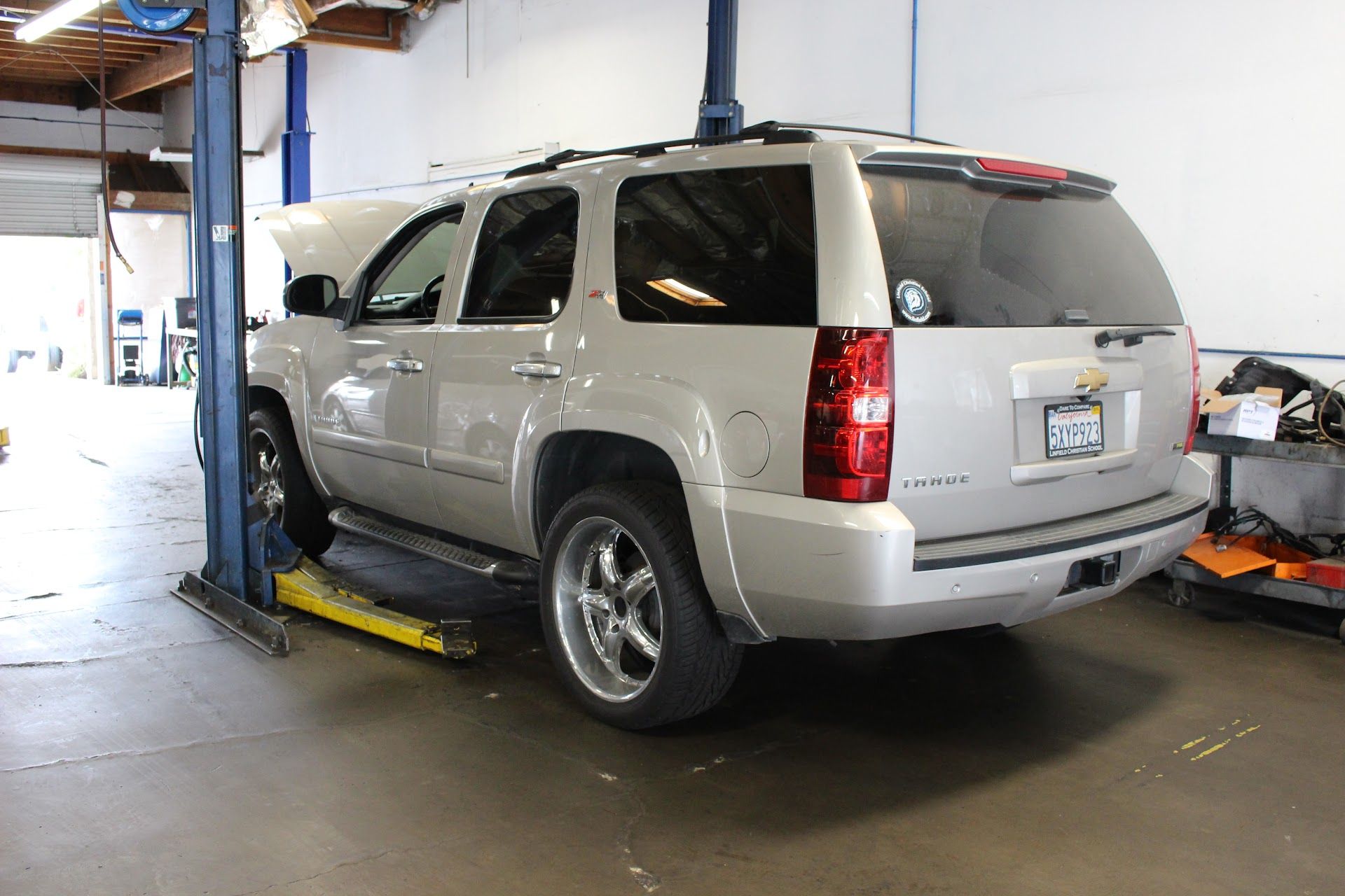 Silver SUV on a car lift in an auto repair shop garage | Agape Auto Repair