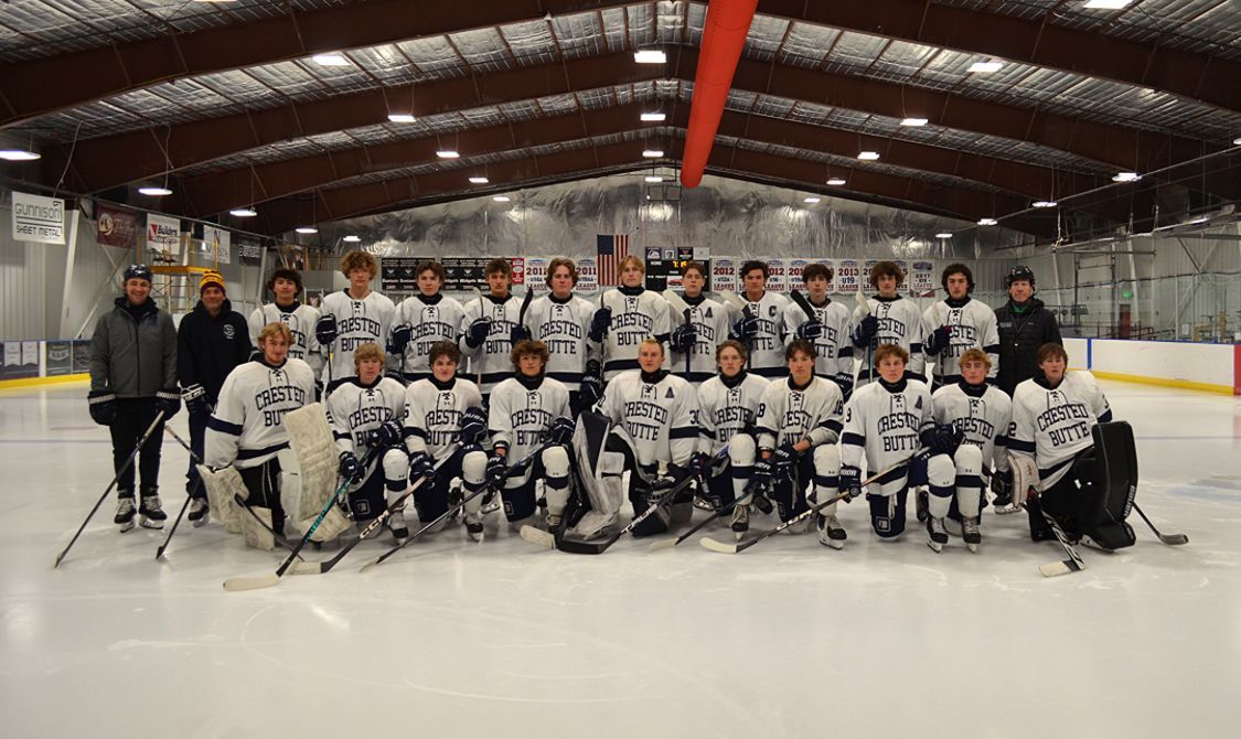 A hockey team is posing for a picture on the ice.