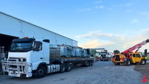 Logistics yard with stacked containers and a truck loading