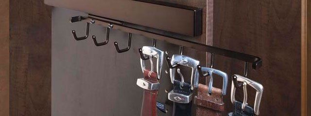 A bunch of tools are hanging from hooks on a rack.