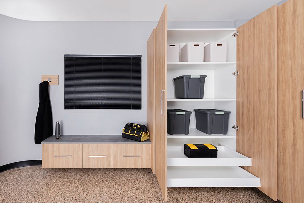 A modern home storage unit featuring wood-tone cabinetry, a bench, a wall-mounted display, and an open, pull-out closet.