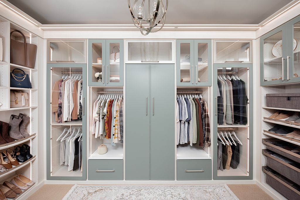 a walk in closet filled with lots of clothes and shoes .