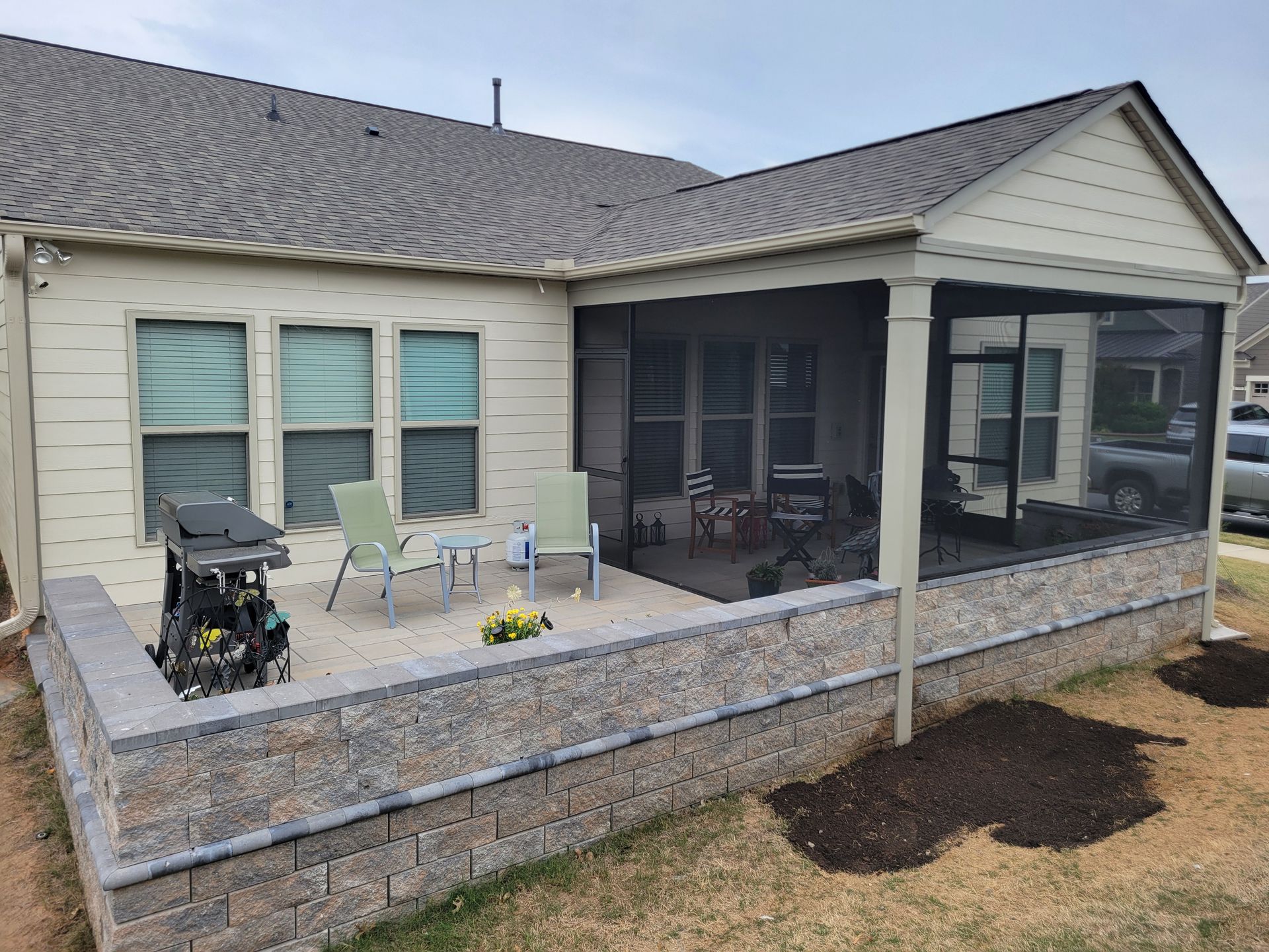Back patio with screened porch, outdoor seating, and a wheelchair lift beside the house