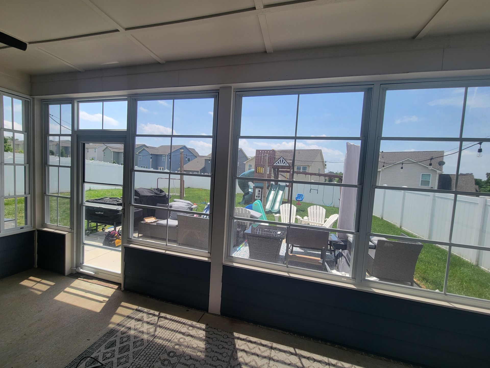 Sunroom with large windows, open door, and a view of a patio and fenced backyard