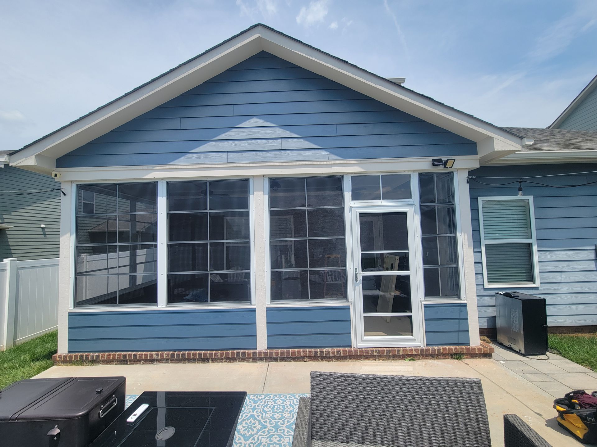 Blue house front with screened porch and white trim
