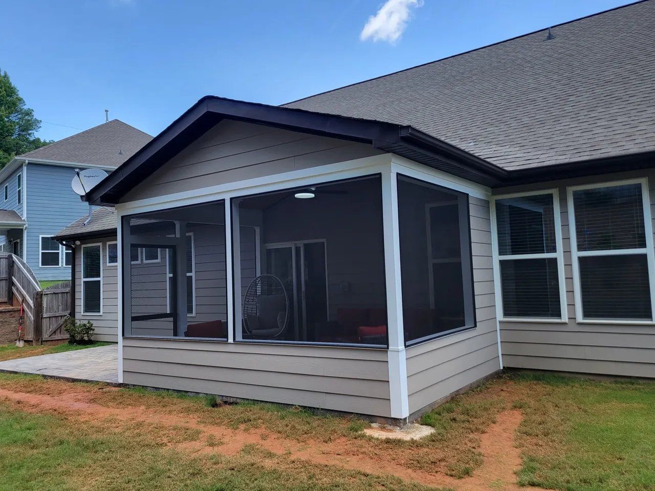 Suburban house with screened front porch, gray siding, white trim, and a shingled roof