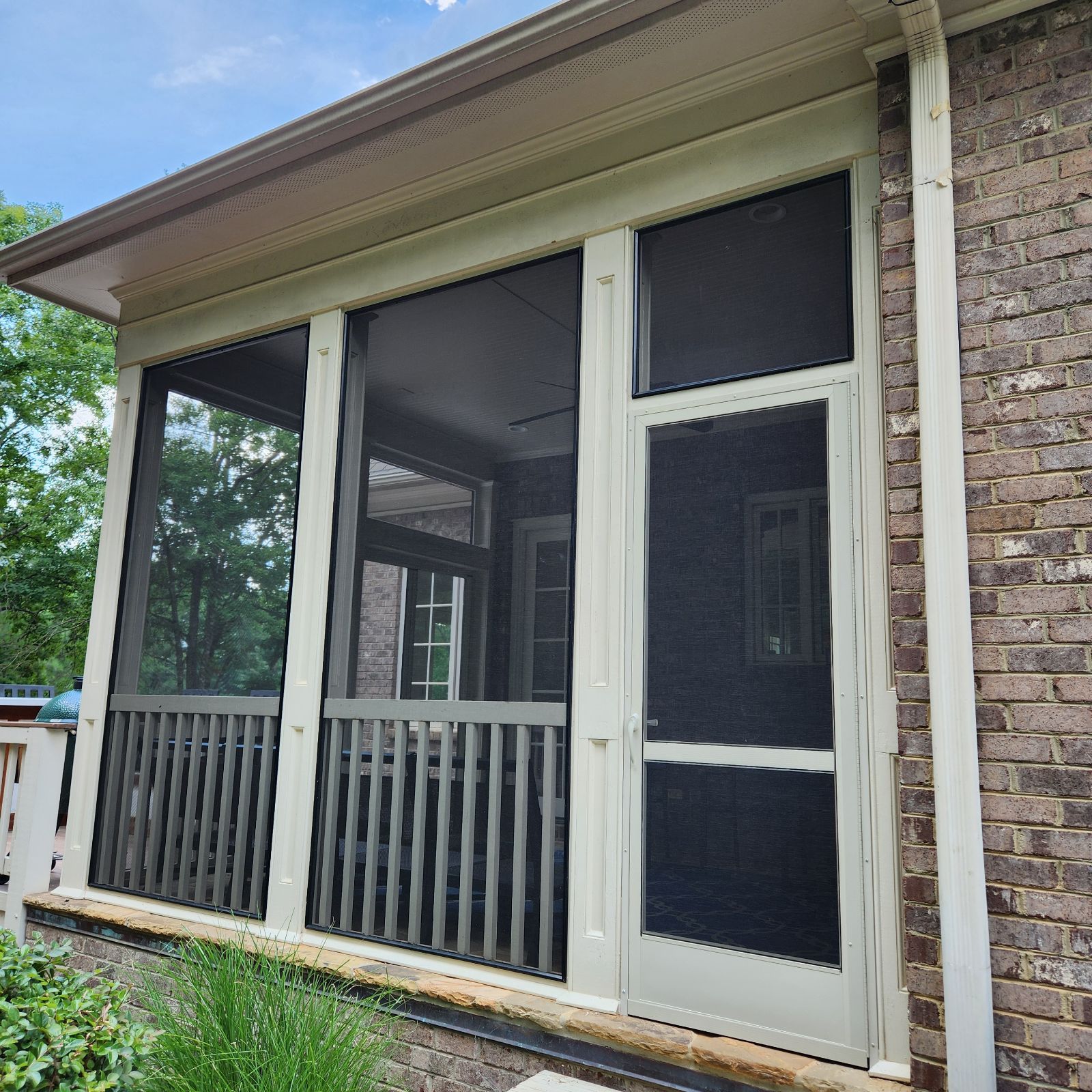 Screened front porch with white trim and stone siding on a house