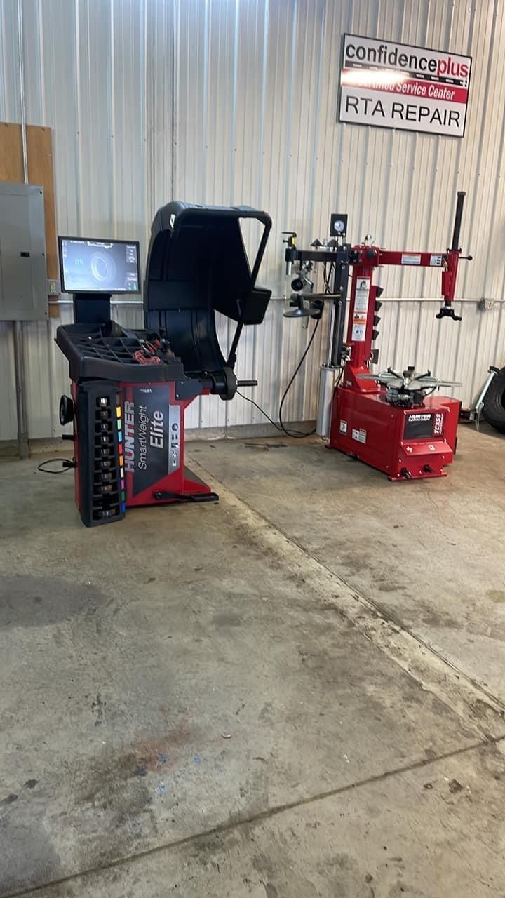 A tire shop with a red and black wheel balancer and tire changer machines | RTA Repair