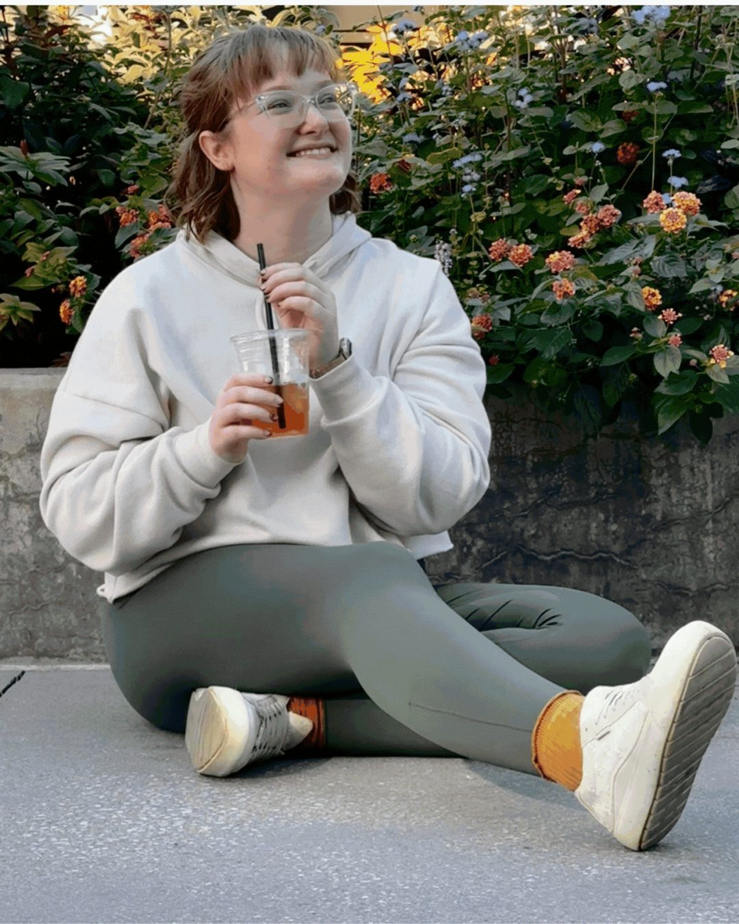 A woman wearing glasses and earrings is sitting in a car.