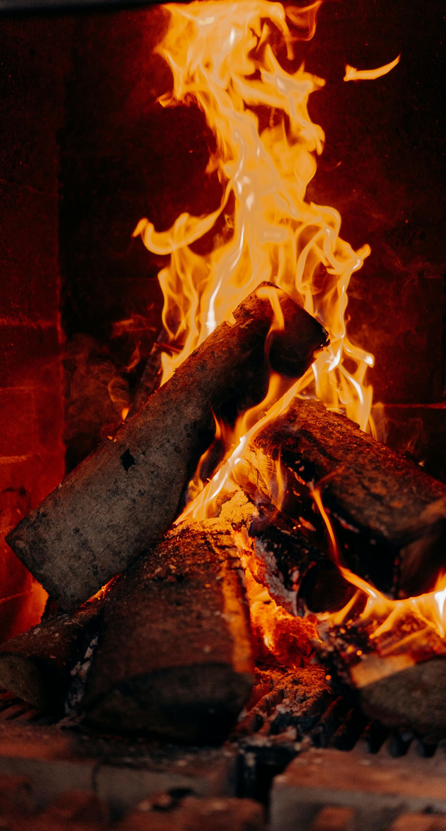 Burning logs in a fireplace with bright orange flames