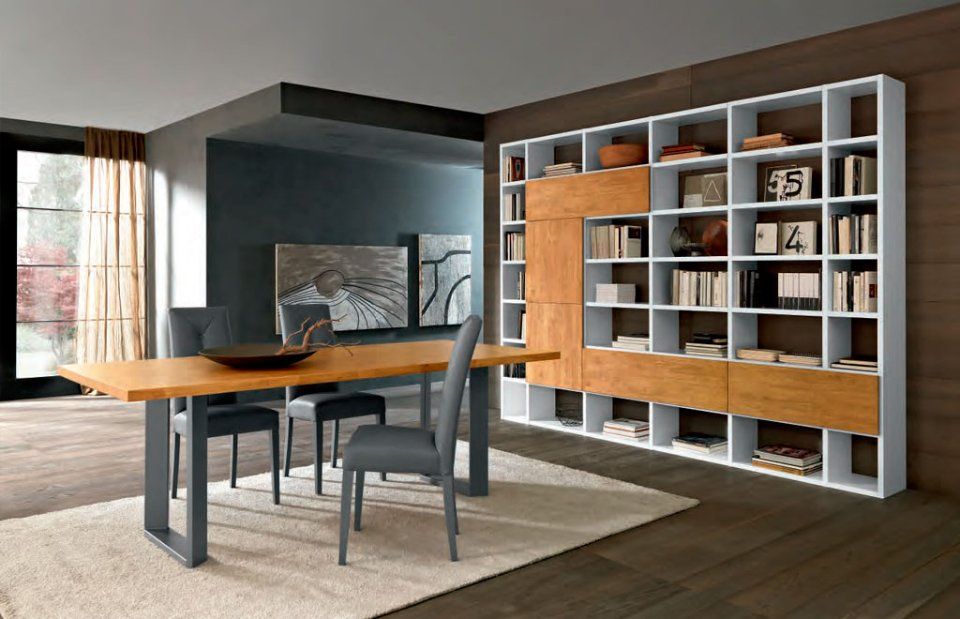 ampia zona living con tavolo in legno e libreria