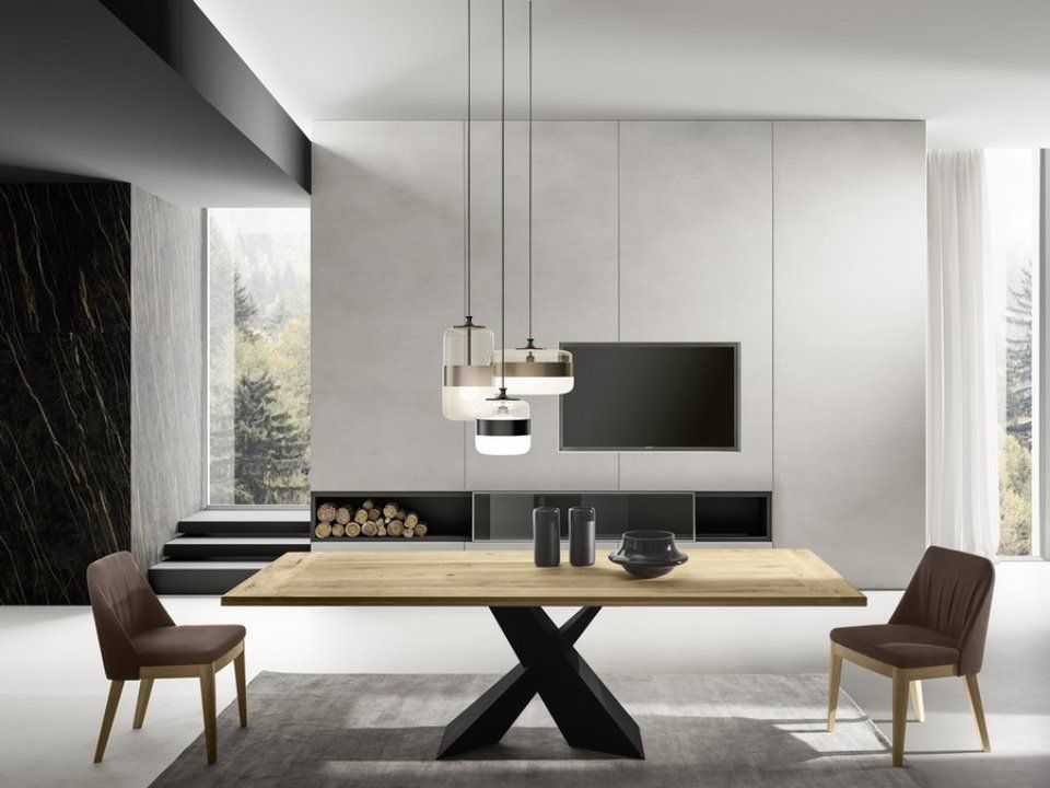 zona living con tavolo in legno e gambe a incrocio