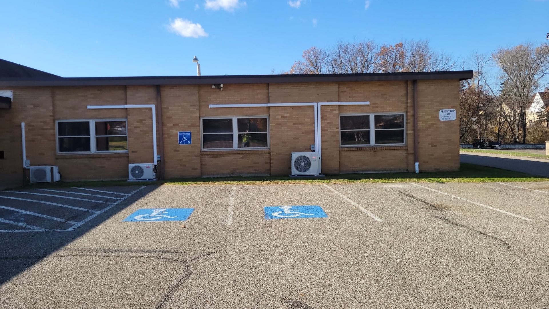 One-story brick building with two accessible parking spaces and blue handicap symbols in front