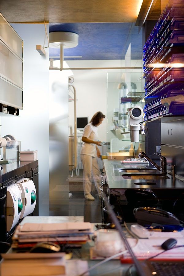 Una donna sta pulendo il bancone di uno studio dentistico.