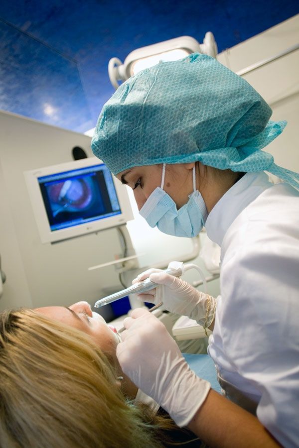 Una donna si sta facendo visitare i denti dal dentista.