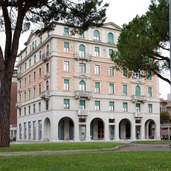 Un grande edificio con molte finestre in una giornata nuvolosa
