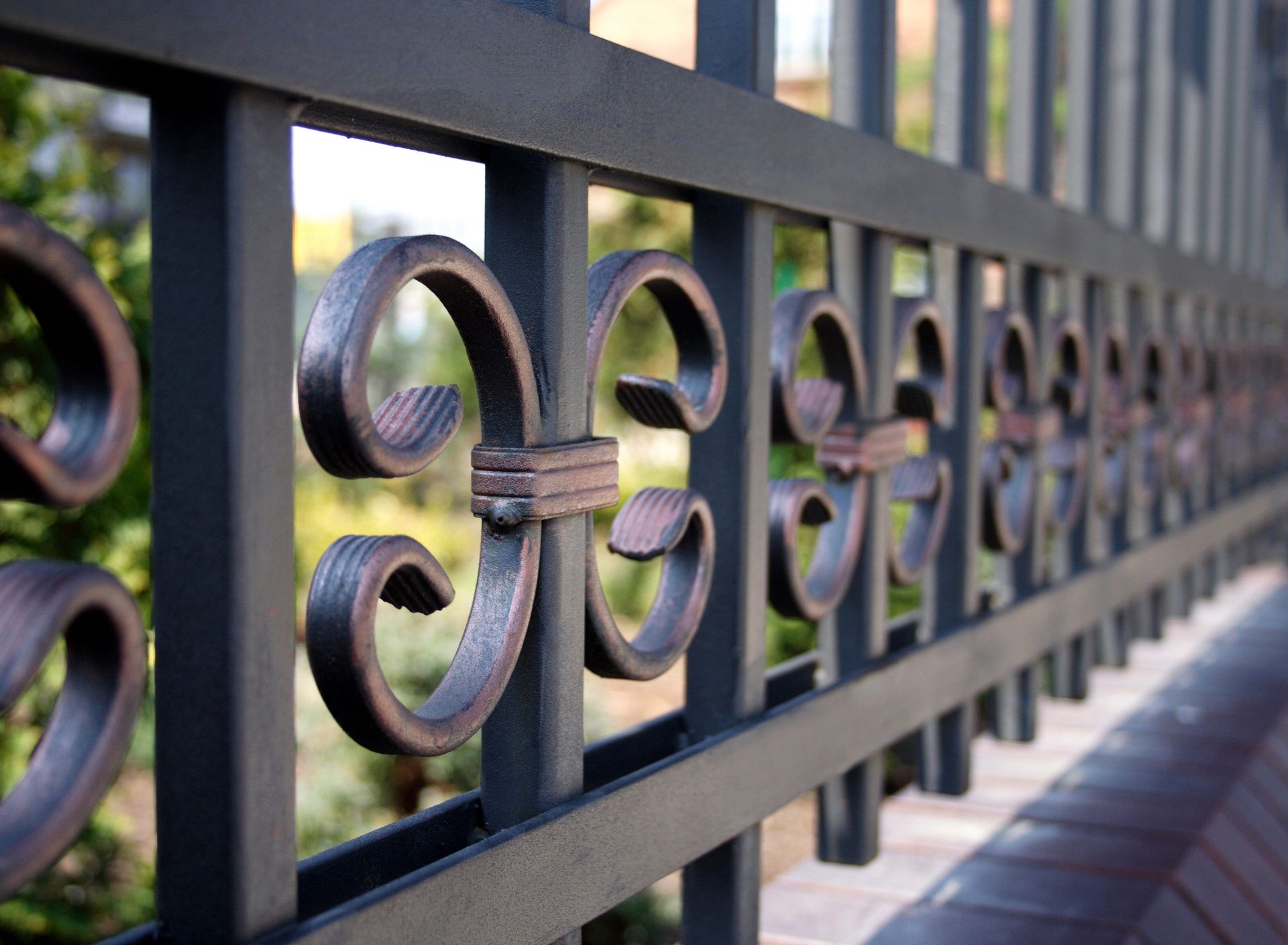 Black wrought iron fence with decorative scrollwork detail.
