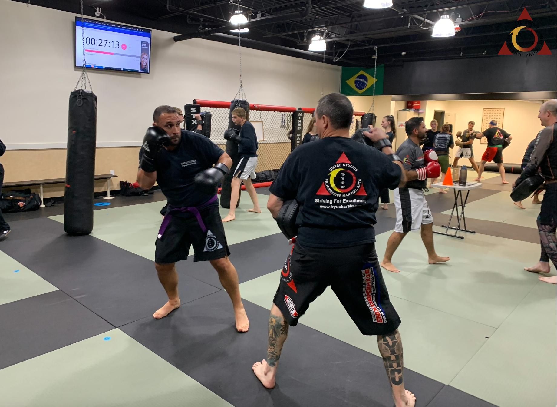 A group of men are practicing martial arts in a gym.