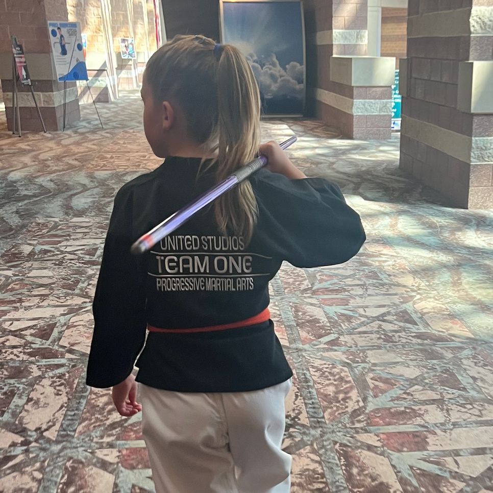A little girl wearing a black shirt that says team onc