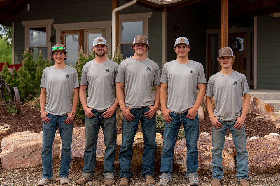 The Tarr Property Services crew seated on a stone wall