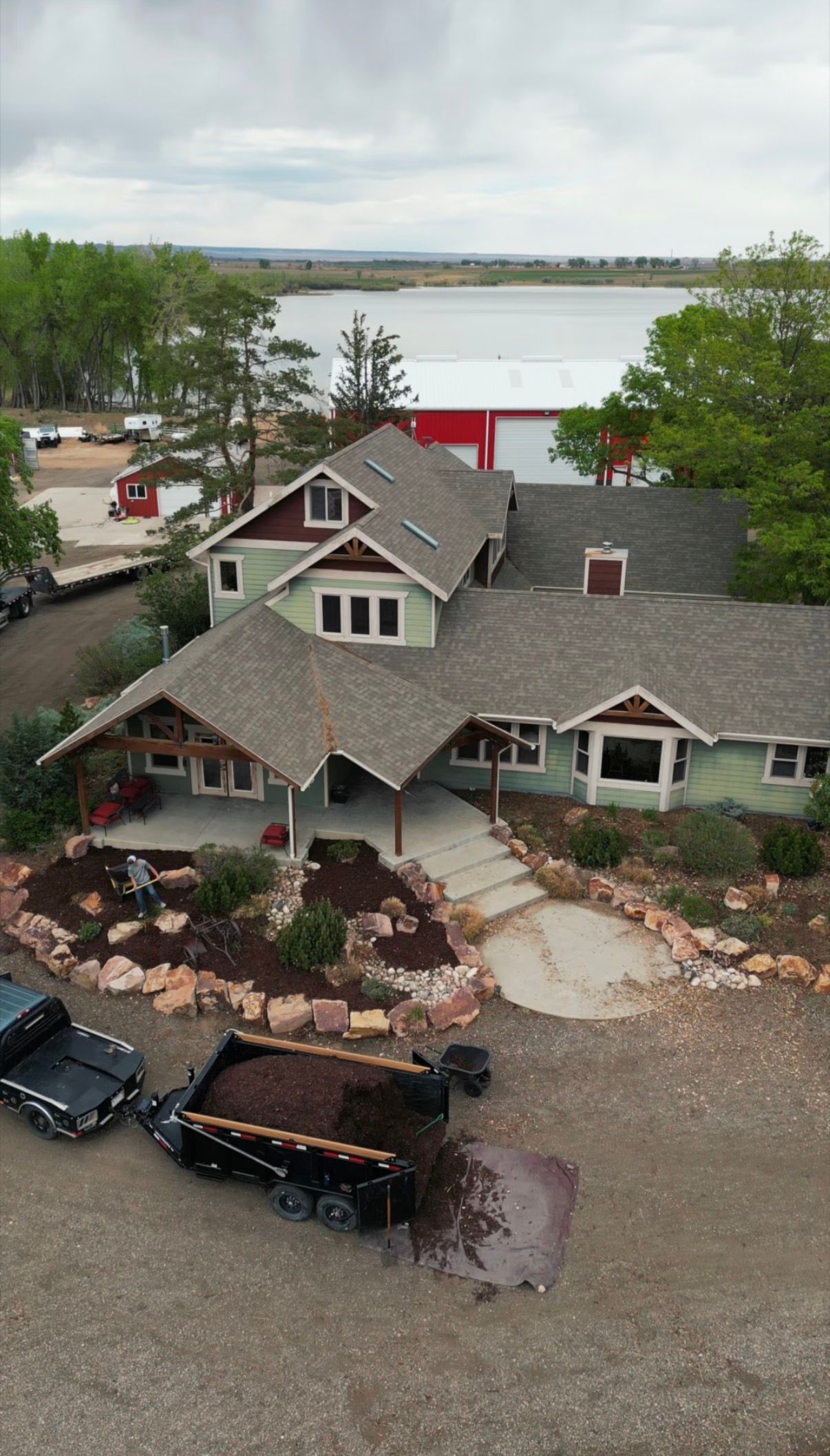Curved mulch bed with boulders and a paver border
