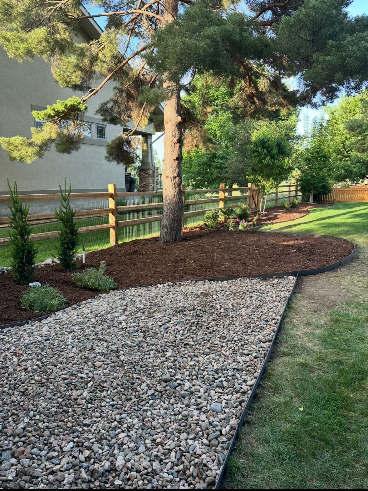 Landscaped bed with boulders, grasses, and a stone border